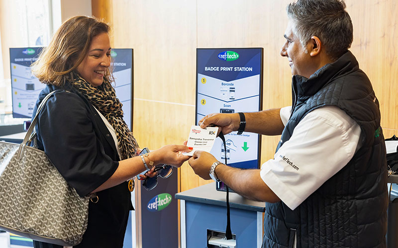 man handing a badge to a woman